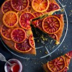 Cake with blood oranges on top and a slice missing