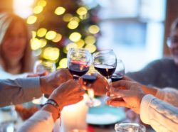 A group of people clinking their wine glasses over a table of food