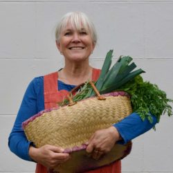 Photo of Jenny Chandler holding a basket of vegetables