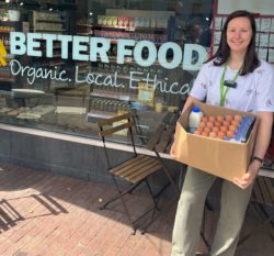 team member outside the shop with a box of ingredients donation